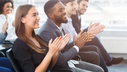 seated attendees applauding at a live event